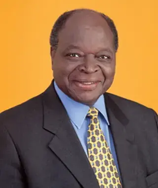 Colour portrait of President Mwai Kibaki wearing a dark suit, blue shirt and patterned yellow tie against an orange background.