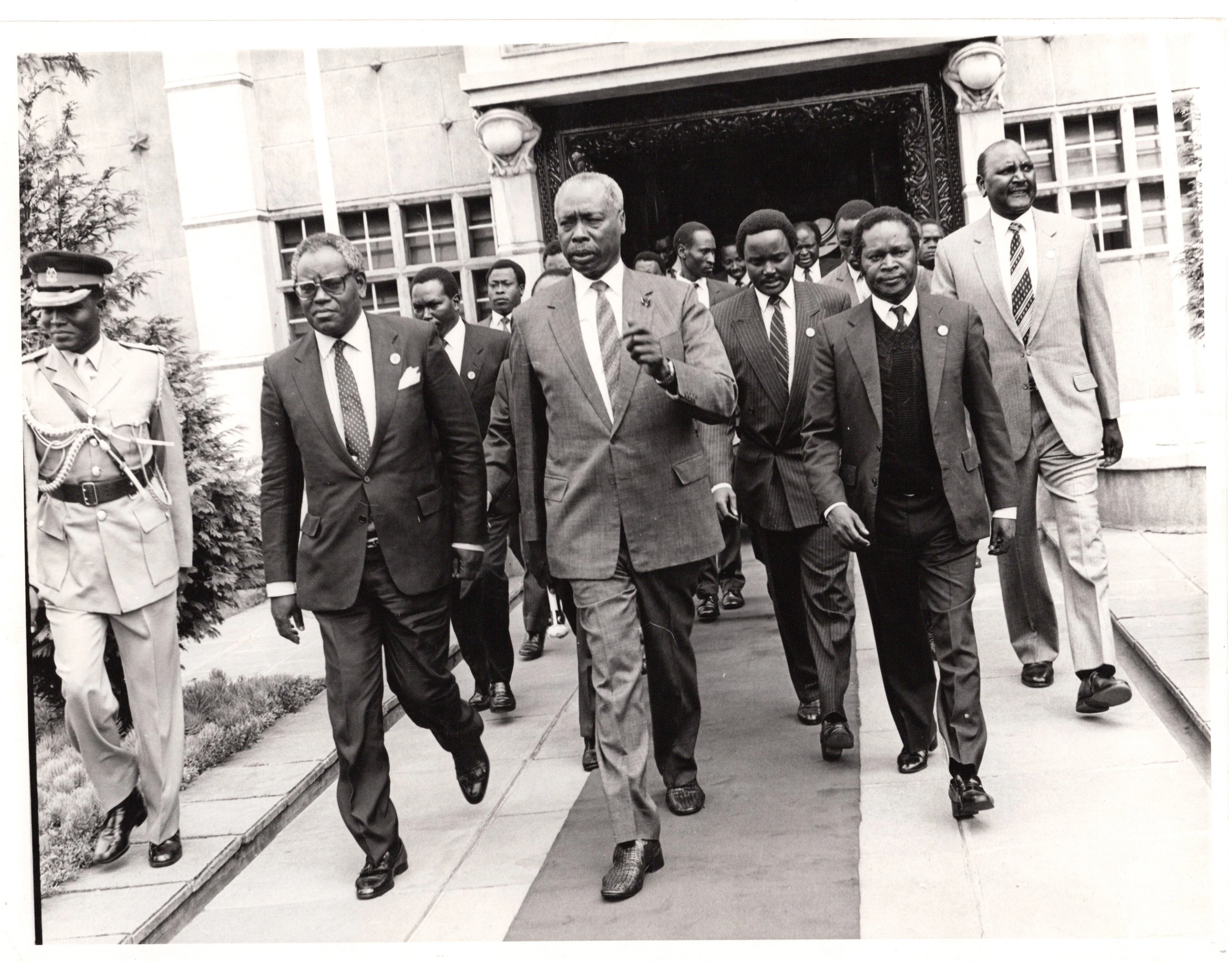 President Daniel Arap Moi leaving Parliament buildings escorted by VP Josphat Karanja after chairing a KANU parliamentary group meeting 