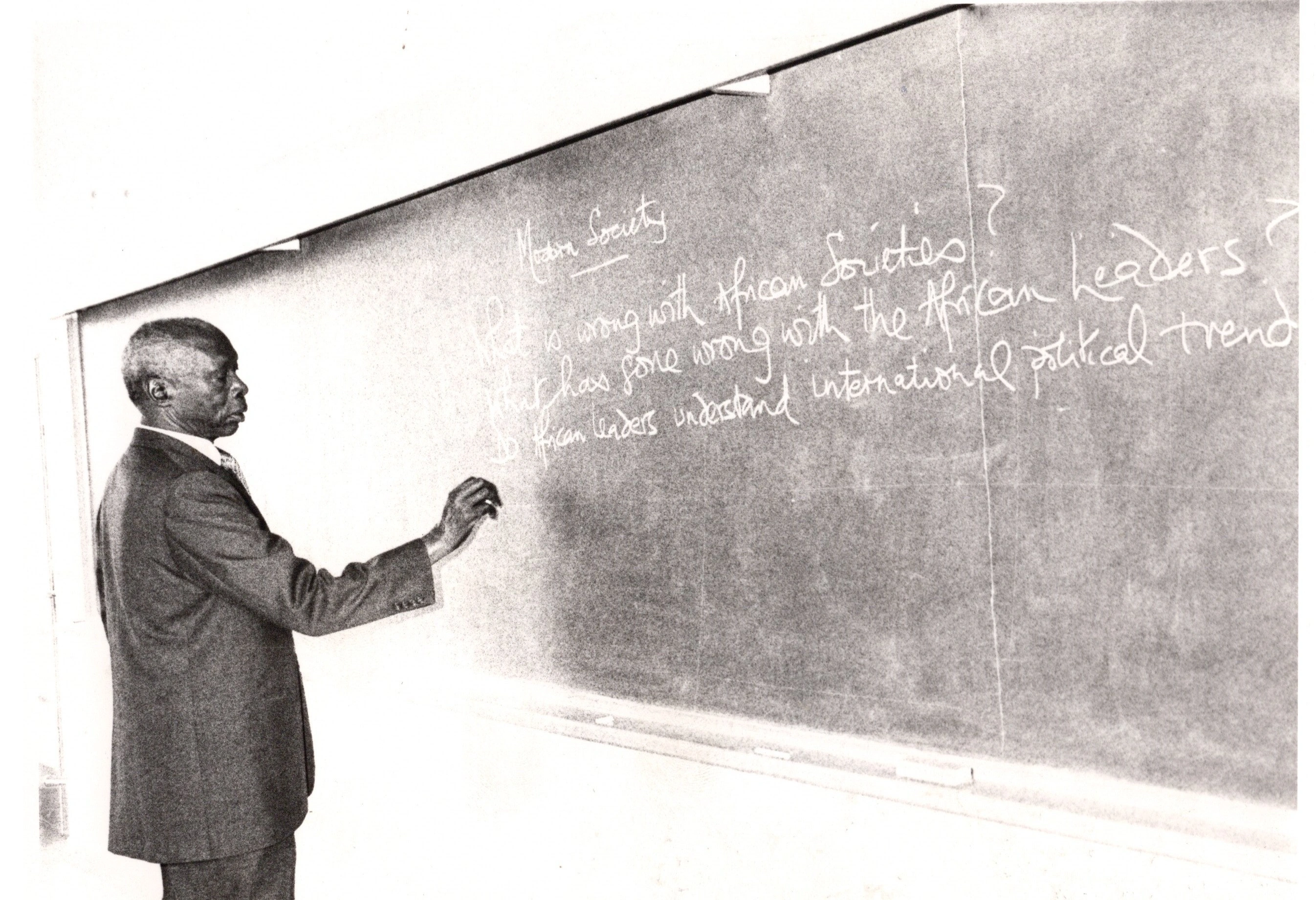 President Daniel Arap Moi writing on the Blackboard of one the 8.4.4 classes during the Kenyatta University graduation ceremony