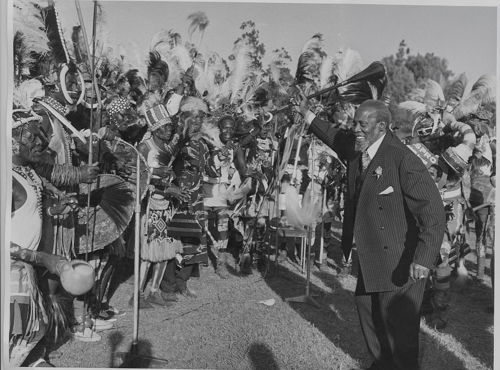 President Jomo Kenyatta being entertained by Luo traditional dancers during Jamhuri Day celebrations