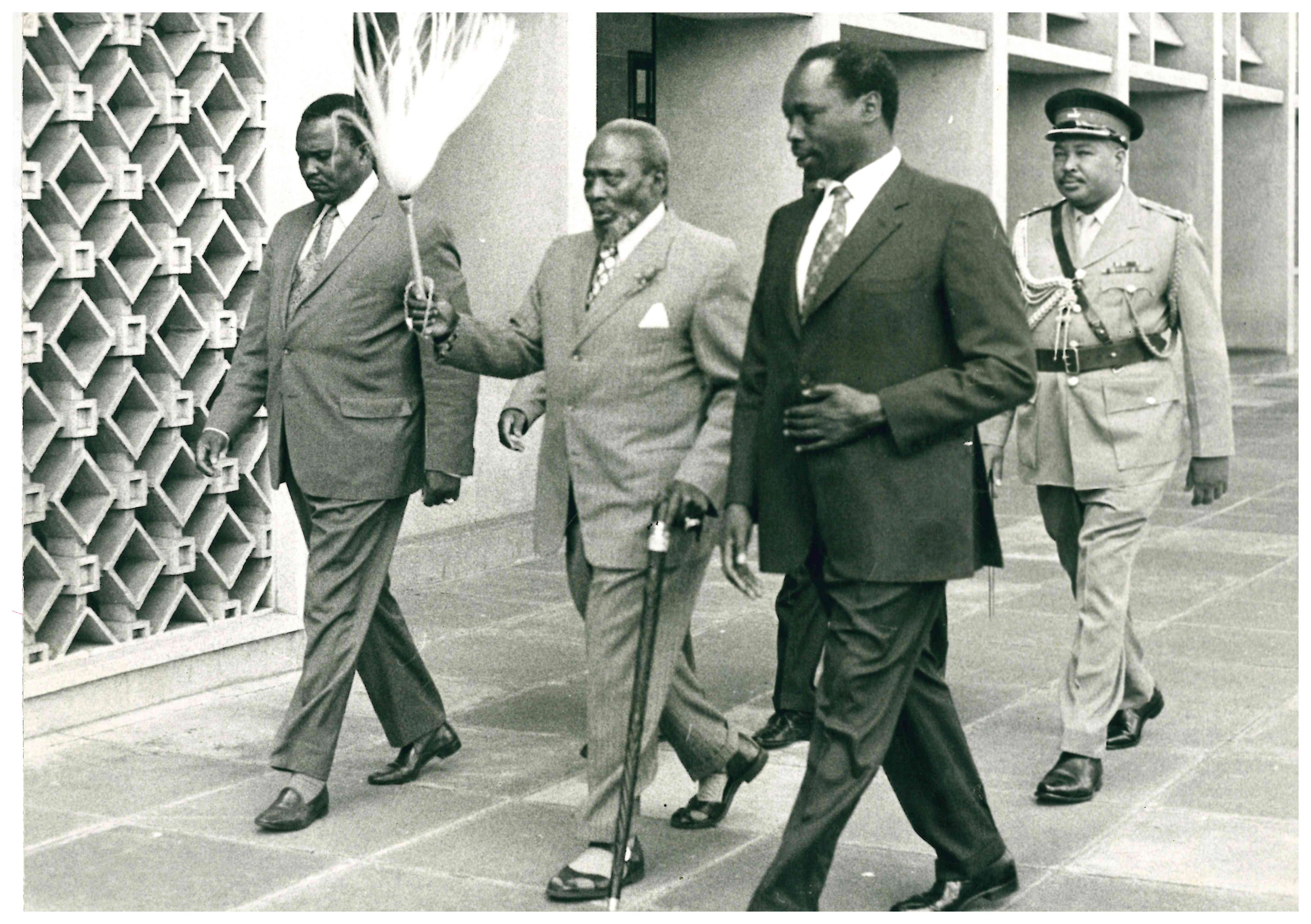President Jomo Kenyatta is seen walking while sandwiched between VP Daniel Moi and an unidentified senior government official in 1972. The president carries his trademark fly whisk and walking stick.