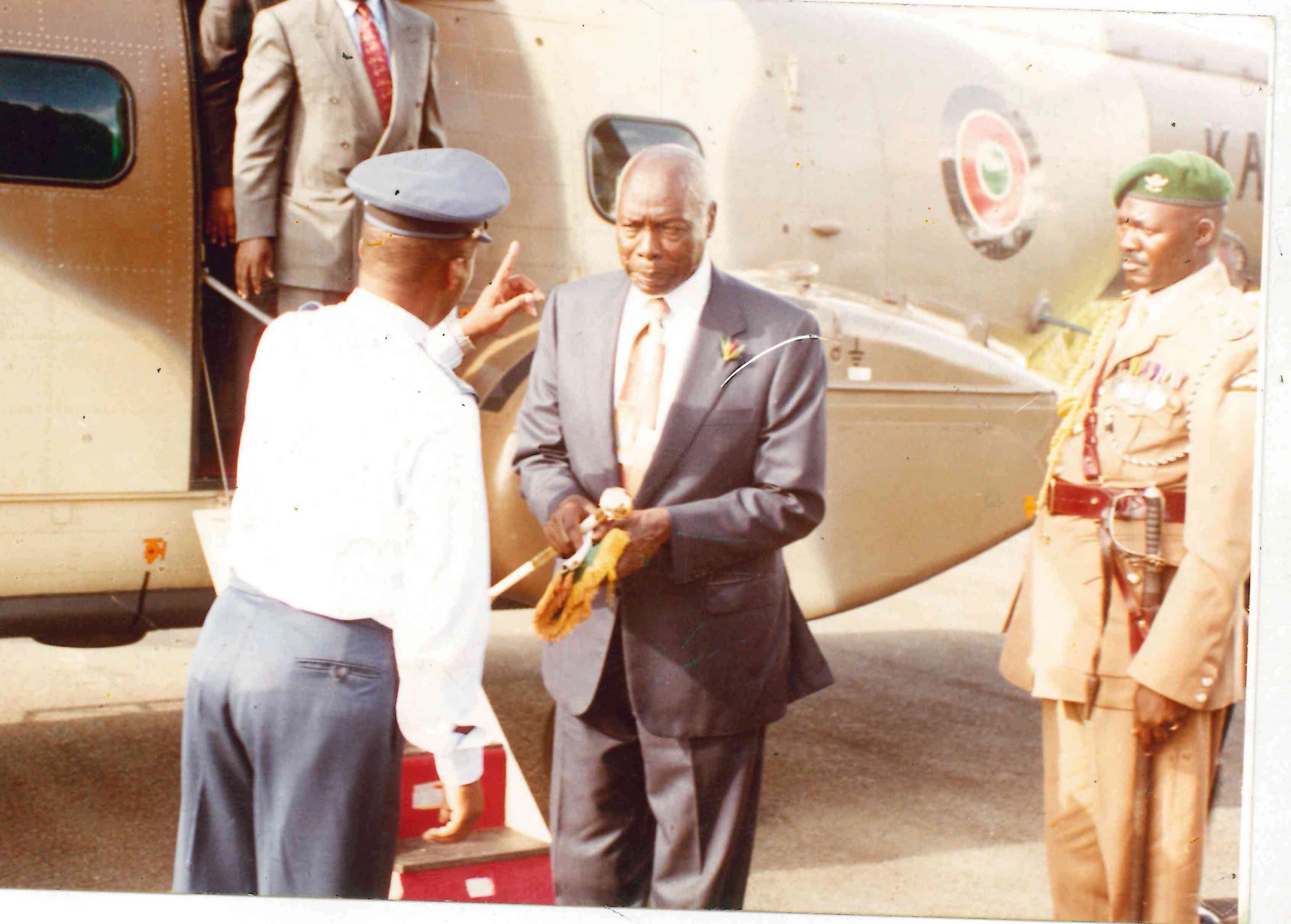 Immediate former President Daniel Arap Moi receives his presidential standard as he returned to his Kabarak home after handing over power to President Mwai Kibaki_30.12.2002
